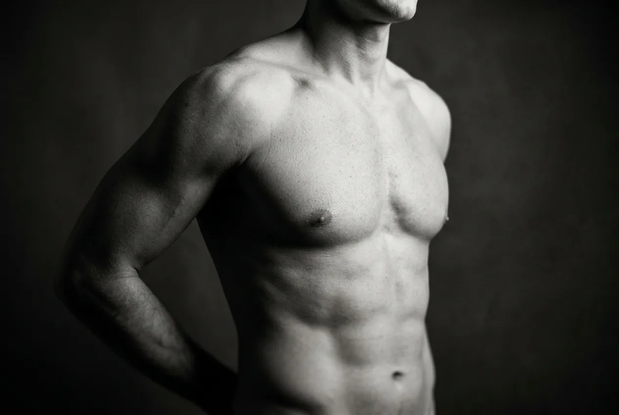 Three-quarter view of a male torso showing a defined pectoral border